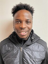 Image of a male standing against an off-white background looking forward toward the camera. This image would be accepted for submission.