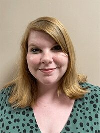 Image of a female against an off-white background looking forward toward the camera. This image would be accepted for submission.