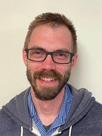 Image of a male standing against an off-white background looking forward toward the camera. This image would be accepted for submission.