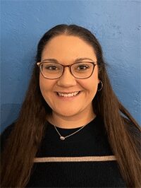 Image of a female standing against a blue background looking forward toward the camera. This image would be accepted for submission.