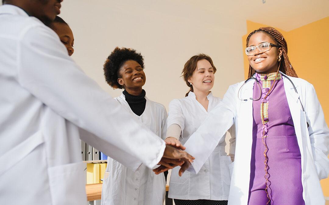 Group of medical doctors and nurses stack hands.