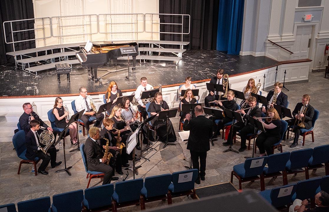 A concert band performing in a chapel.
