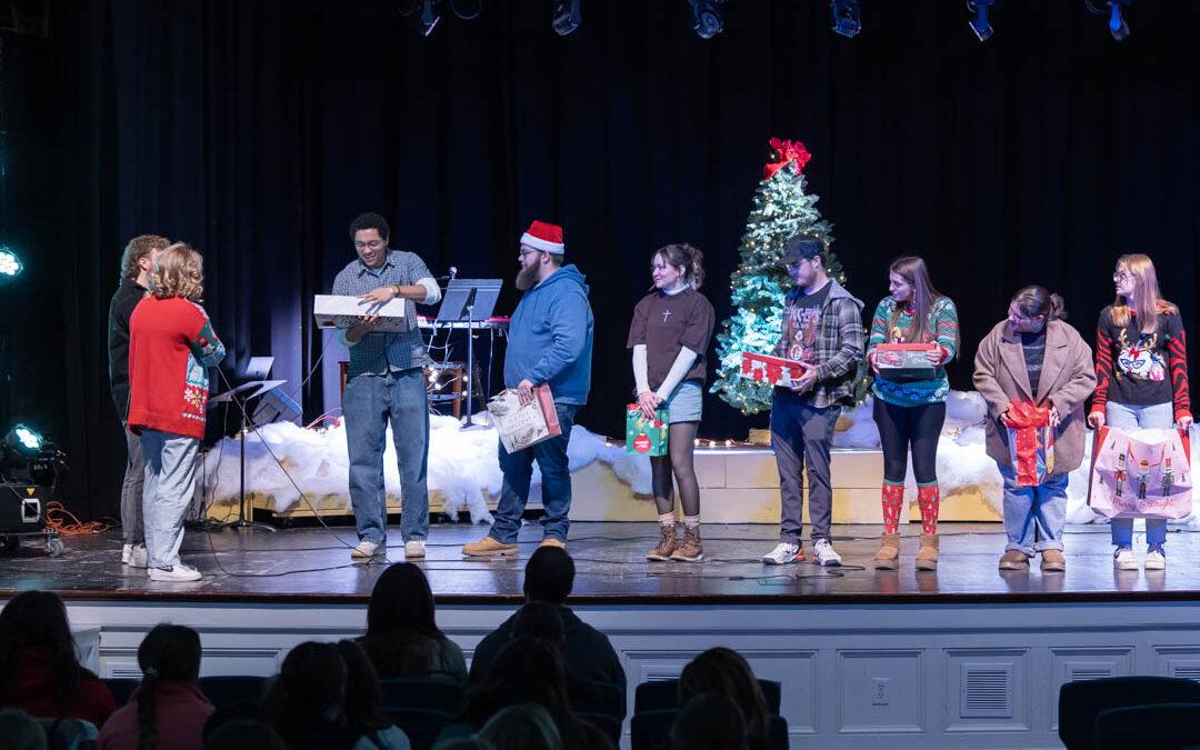 Students open presents on the chapel stage
