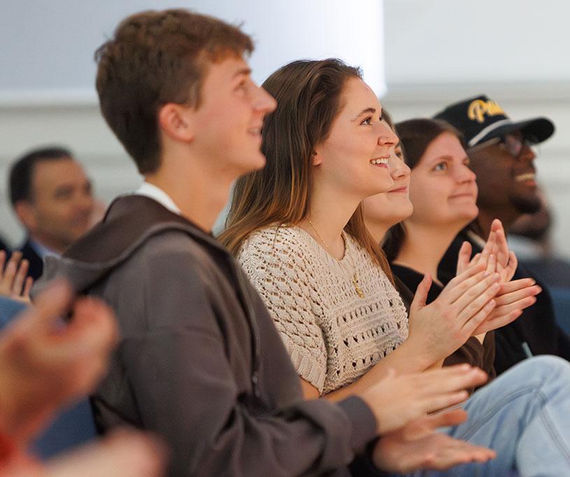 Students clapping sitting down