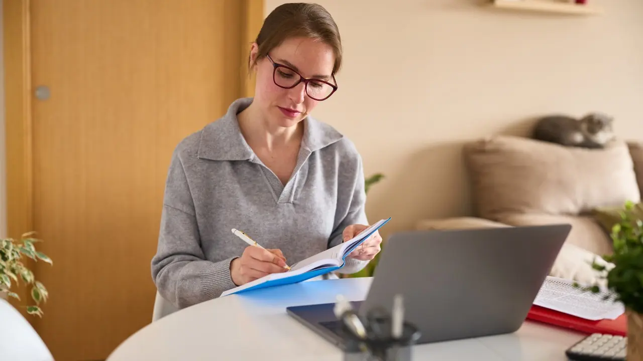 Student-Researching-Transfer-Credits-BU Woman making notes in front of a laptop.