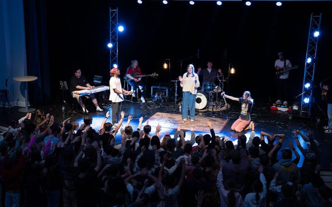 A crowd of worshippers raising their hands.