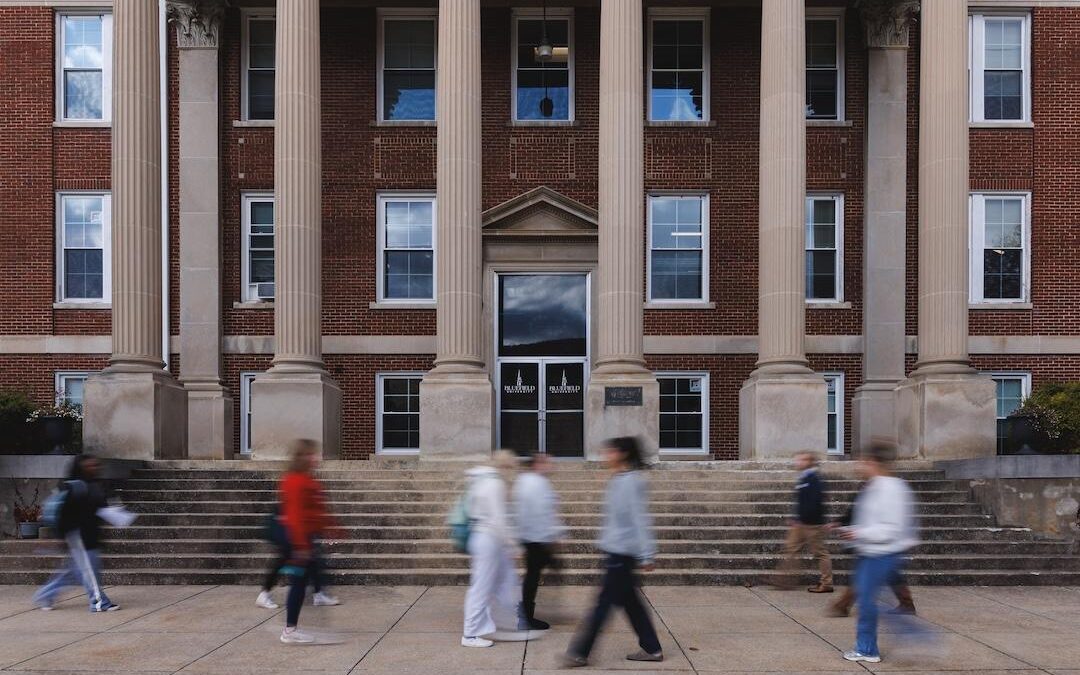 A picture of people walking in front of Lansdell Hall with motion blur.