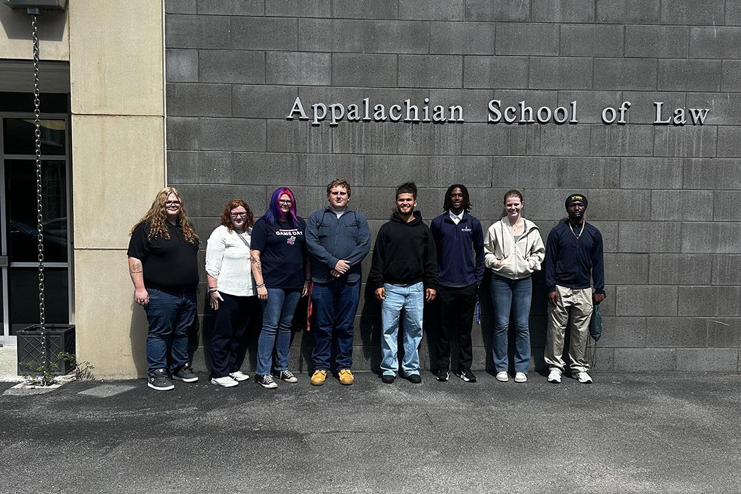 ASL-Tour-Sept-2026 Eight students stand in front of an Appalachian School of Law sign.